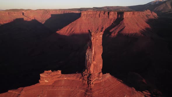Long aerial view of iconic Castleton Tower rock spire in Moab sunset ...