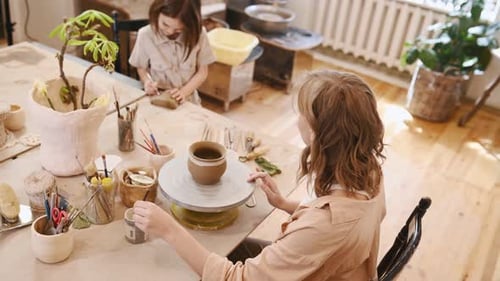Woman Painting a Clay Pot in Pottery Studio