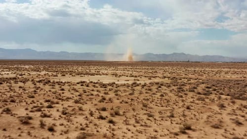 Ein plötzlicher Sandsturm oder Staubteufel schießt Sand hoch in den Himmel, wenn man ihn aus der Luft betrachtet.