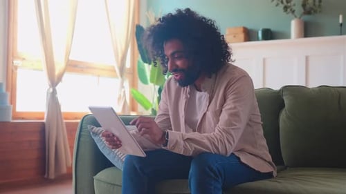 Young Man Using Tablet Device on Couch
