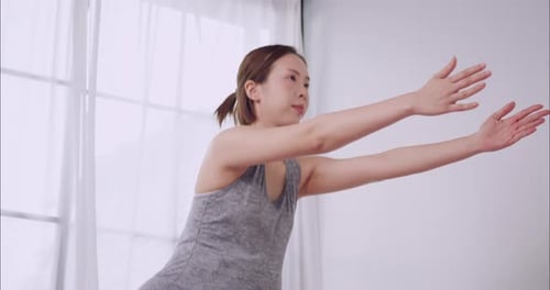 Woman Practicing Yoga in a Bright Home Studio