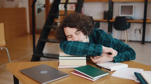 Young Male Student Fell Asleep on a Stack of Books in the Library or Classroom The Guy Was Tired