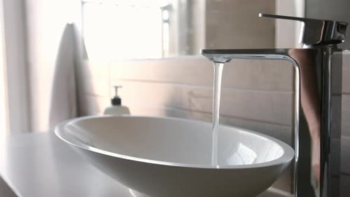 Water Flowing into Modern Bathroom Sink