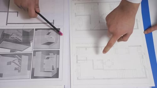 Zwei Ingenieure diskutieren über ein Architekturprojekt. Hände in Nahaufnahme.