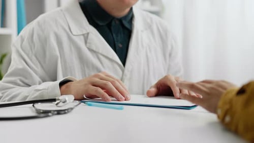 Male specialist in clinic doctor uniform shaking hands with patient meeting doctor's office