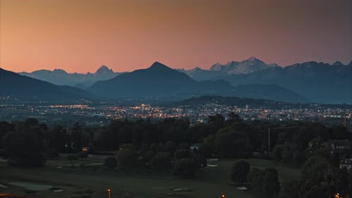 Snowcapped Alpine Mountains and Sparkling Town Lights at Night