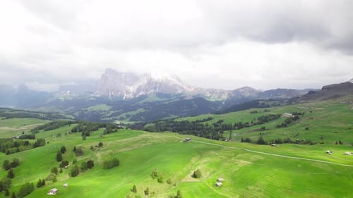 Stunning Aerial View of Lush Green Meadows and Misty Mountains