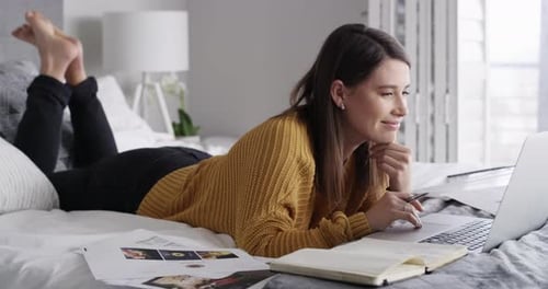 Woman Working on Laptop Lying on Bed