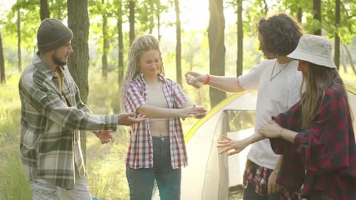 A Group of Young Tourists in a Beautiful Forest Applying Mosquito Repellent at Sunset Against the