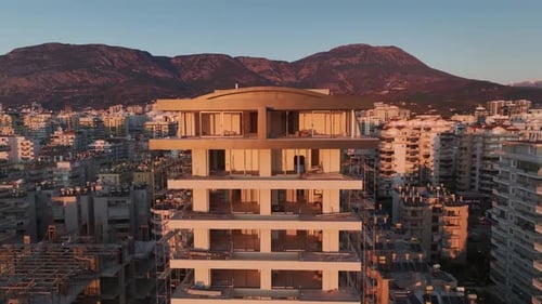Vídeo aéreo: Se está construyendo un edificio de varios pisos en el paseo marítimo con un entorno pintoresco