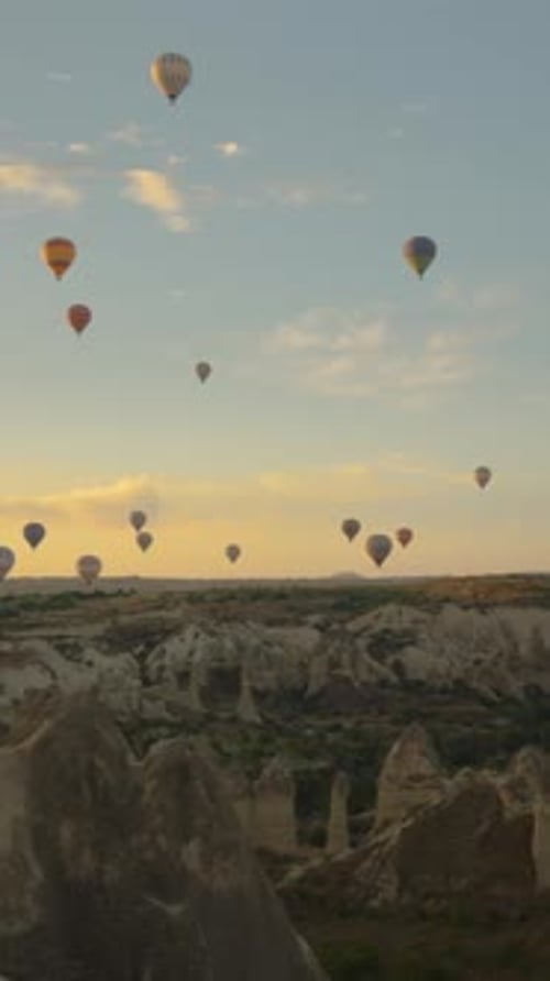 Vertical video. Panorama at dawn from the Valley of Love in Cappadocia, with a multitude of hot air