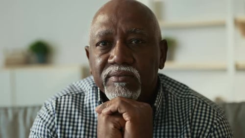 Elderly African American Man Reflects Thoughtfully at Home in Cozy Space