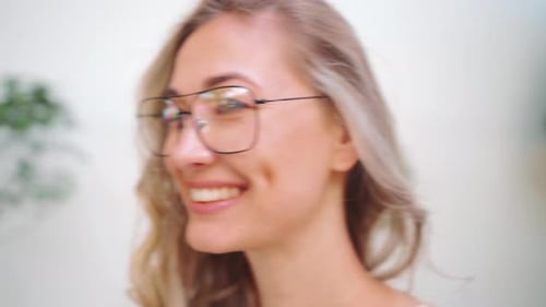 Confident Woman Wearing Stylish Eyeglasses and Smiling at Camera