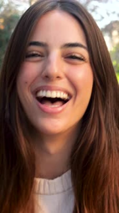 Vertical Video Slow Motion of a Smiling Carefree Young Woman Walking in a City