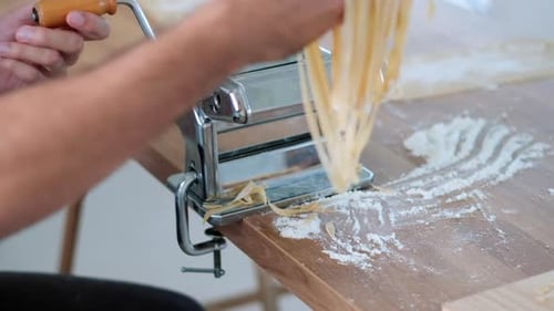 Person Making Fresh Pasta with a Pasta Machine