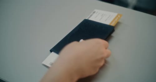 Close Up of Female Passenger Putting American Passport with Airplane Ticket on Checkin Counter