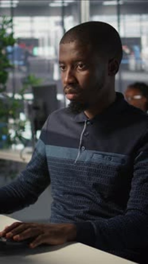 Young Adult Working Seriously At Computer in Office