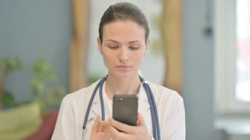 Female Doctor Using Smartphone Inside
