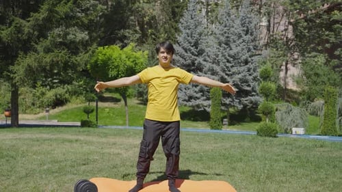 Young Adult Man Stretching Arms in Park