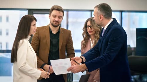 Business meeting in an office, workers discussing business affairs using papers with charts