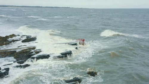 Aerial view of waves crashing against rocks along the coastline during a storm.
Drone Footage.