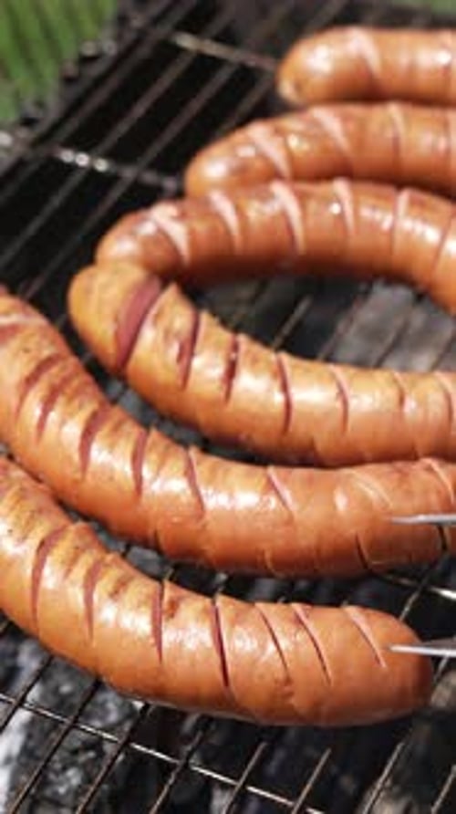 Tasty juicy sausages grilling. Barbecue grill cooking outdoors.