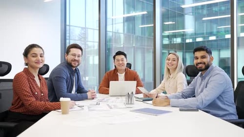 Portrait of group multiethnic business team sitting in modern office boardroom looking at camera