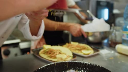 Le chef râpe de la poutargue dans une assiette de spaghettis italiens aux palourdes