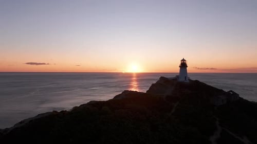 Lighthouse Perched on Rock By the Ocean