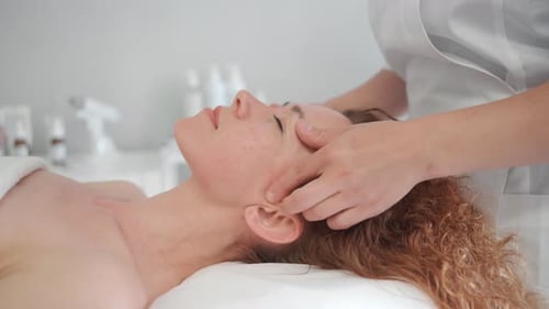 Massoterapeuta massageando rosto e corpo de mulher