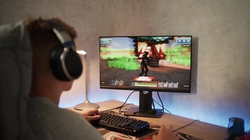 Adolescente caucasiano joga jogo de tiro em terceira pessoa em 3D no computador