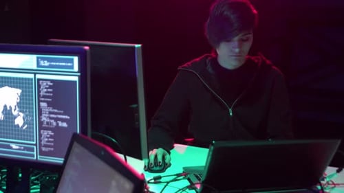 Young Adult Coding at Multiple Computer Screens