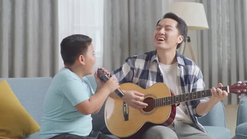 Father and Son Play Guitar and Sing at Home