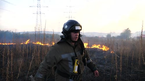 Firefighter Walking Near Burning Field