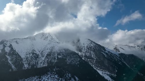 Aerial View of Snow-Capped Mountains with Blue Sky