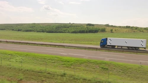 Blue Semi-Truck Driving on Rural Highway