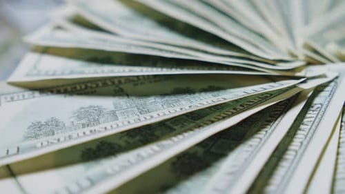 Nahaufnahme von einhundert-Dollar-Scheinen in Zeitlupenaufnahmen