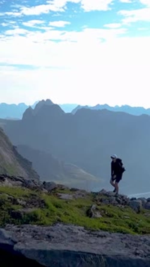 Aerial View of a Girl with a Backpack Traveling Through the Mountains of the Lofoten Islands