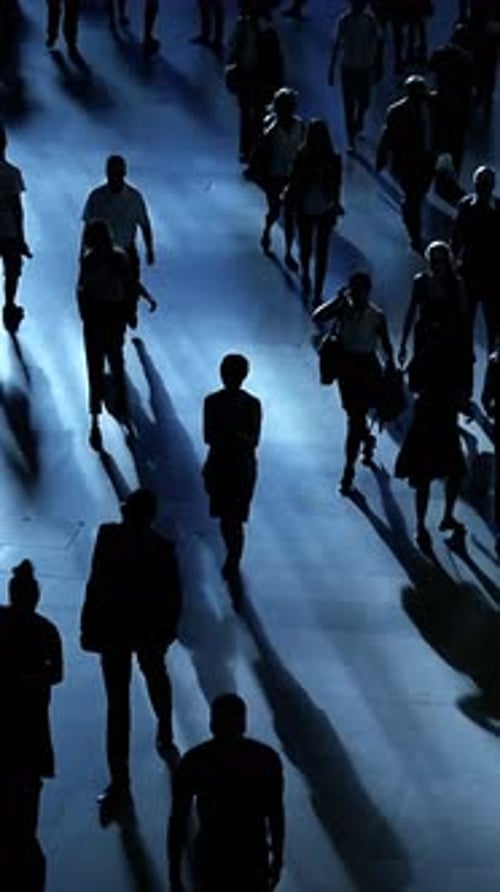 Silhouetted People Walking in an Urban Setting at Night