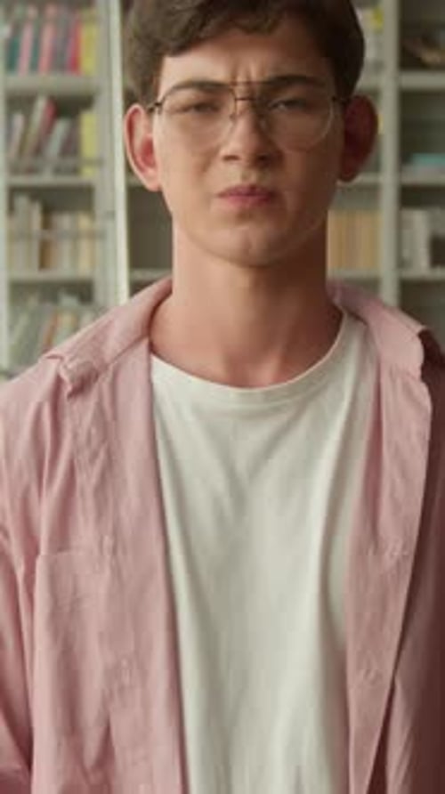 Dissatisfied Caucasian Guy Student Showing Thumb Down Gesture Reject in Library Upset Teen Boy Frown
