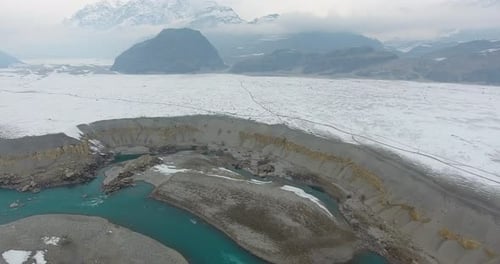 Aerial view of snowy mountains and serene lake, Pakistan.