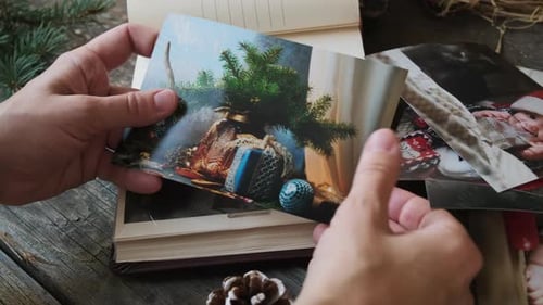 Mujer selecciona fotos impresas de Navidad para un álbum de fotos familiar