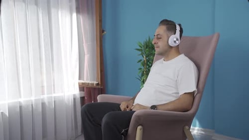 Man Enjoying Music with Headphones in Chair