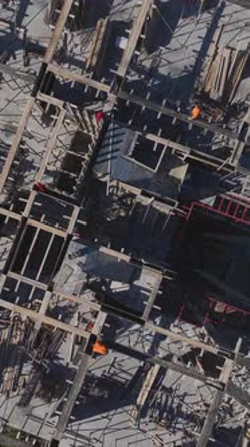 Vertical Video of Workers Building Walls and Foundations While Engineers Oversee the Project
