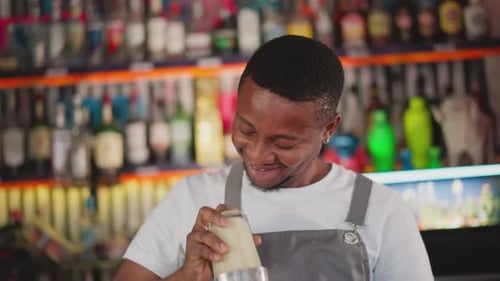 Barman Prepares Drink with Shaker in Bar