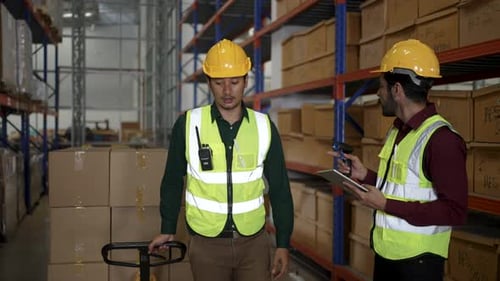 Blue collar workers are working at warehouse.