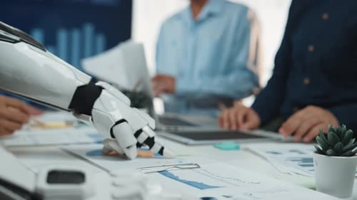 Robot Arm and People Analyzing Charts in Office