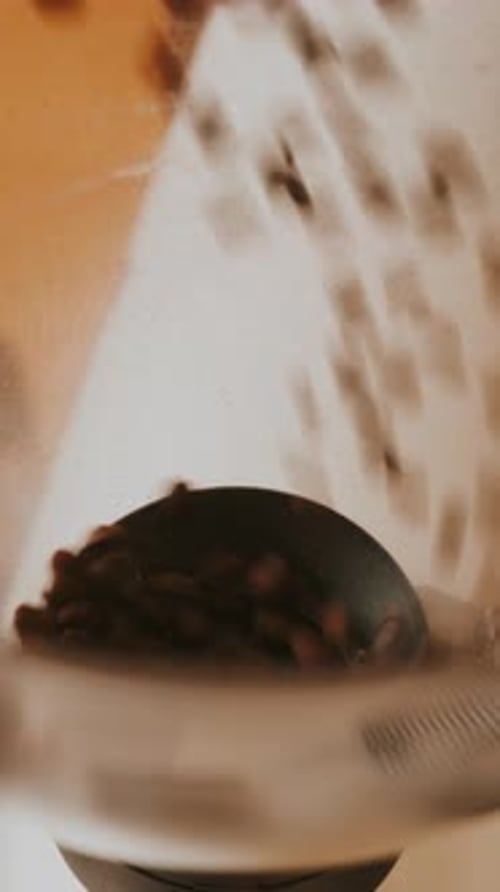Close Up View of Pouring Fresh Coffee Beans in Coffee Grinder