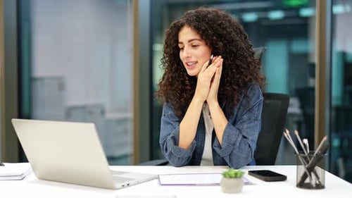 Confident Businesswoman in Modern Office Using Laptop for Video Call
