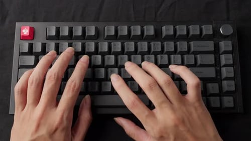 Hands typing rapidly on a mechanical keyboard, clear audible clicks, focus on fingers, indoor settin